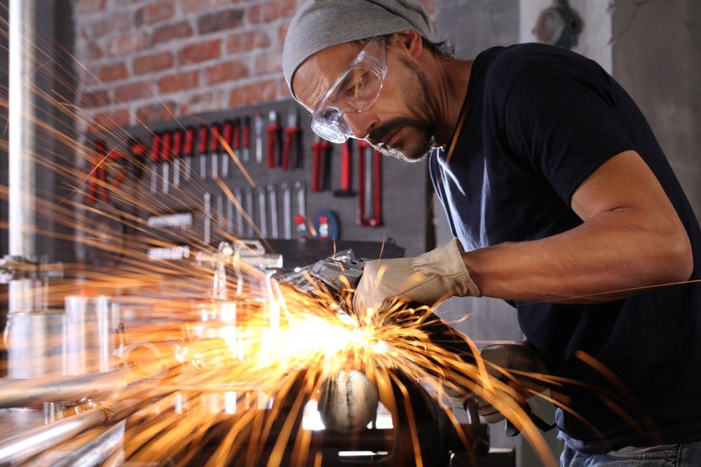 welder working at home workshop with goggles