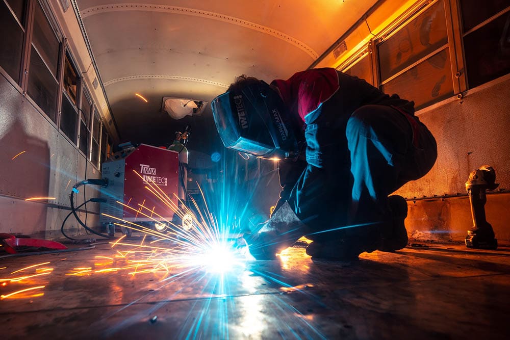 man welding a bus