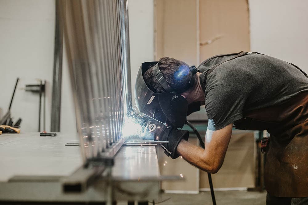 man welding stainless metal