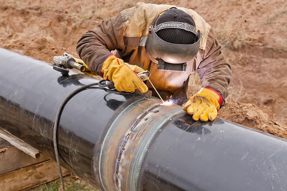 person welding a black pipe