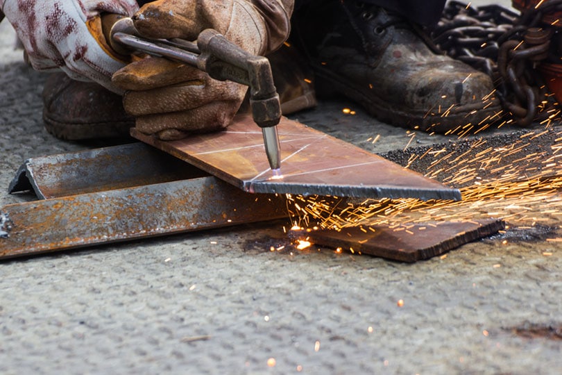 worker cutting steel plate with plasma cutting machine