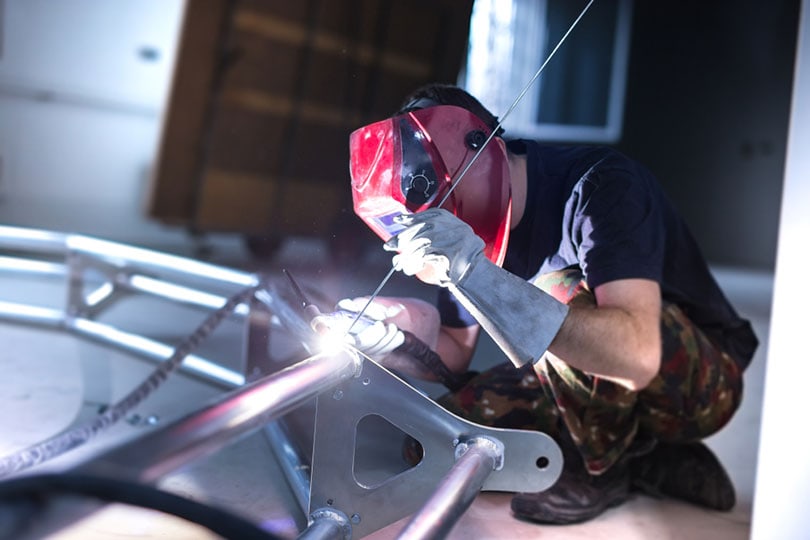 worker welding aluminum truss using tig welder