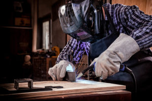 welder wearing helmet and gloves